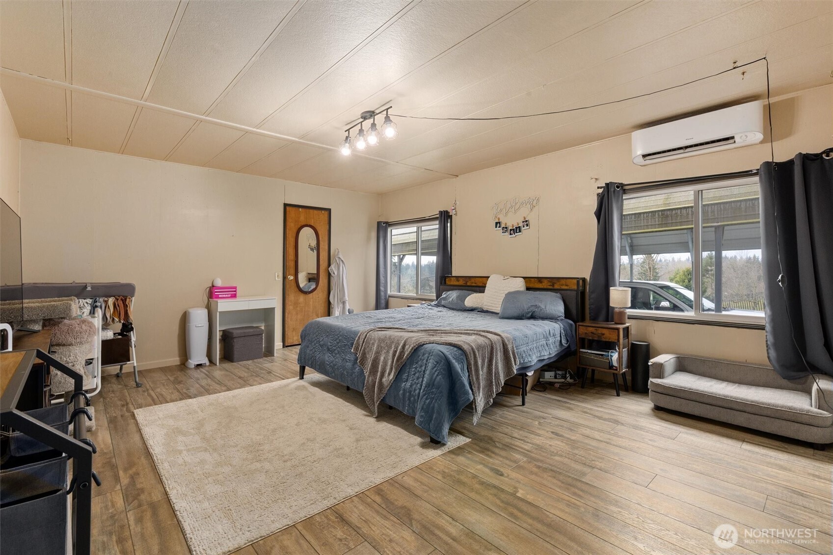 14601 Jim Creek Road Arlington, WA 98223 - Photo 15 of 35 a spacious bedroom with a large bed a chandelier and windows