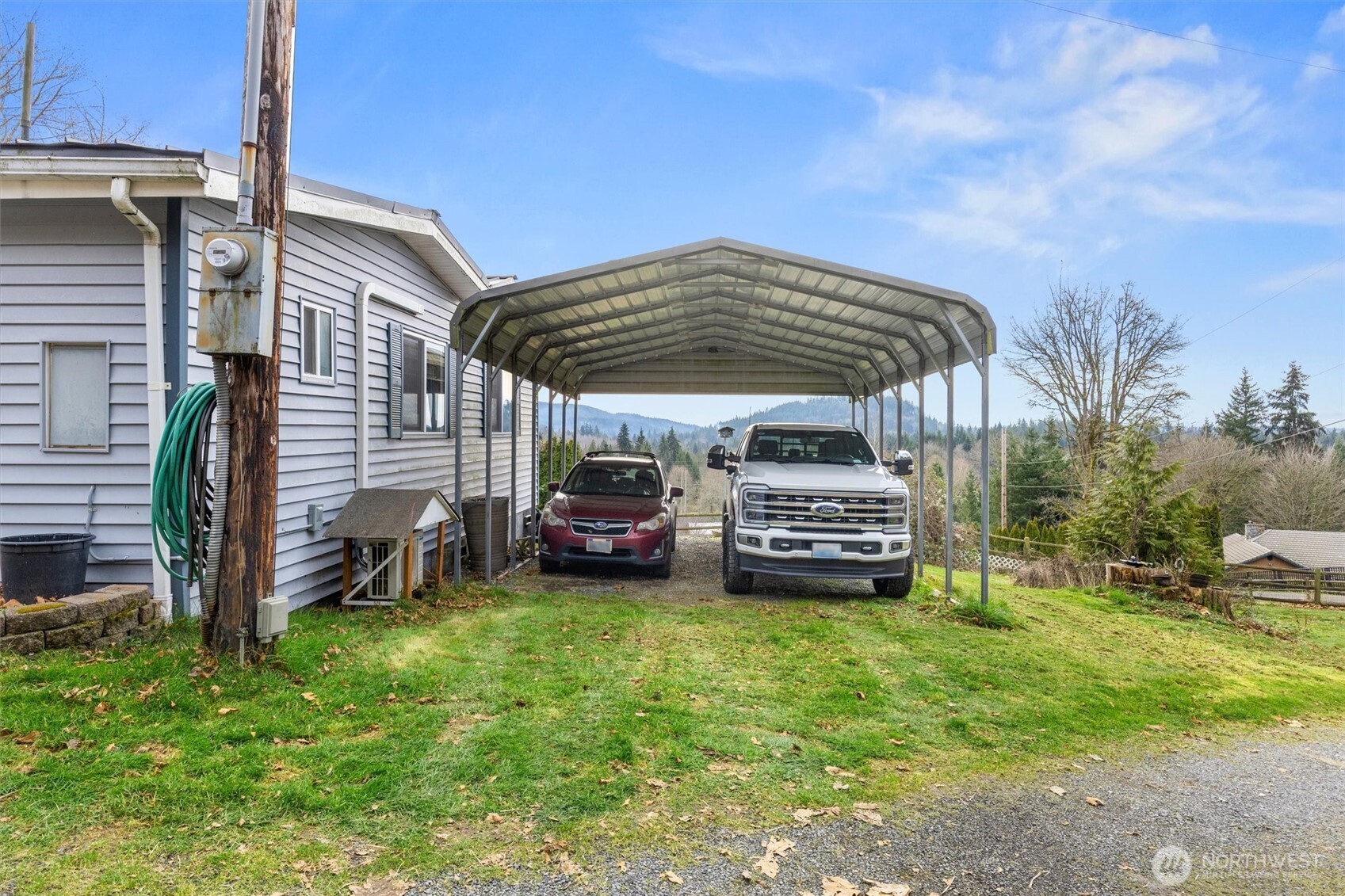 14601 Jim Creek Road Arlington, WA 98223 - Photo 34 of 35 a view of a house with a barbeque and a car parked in the yard