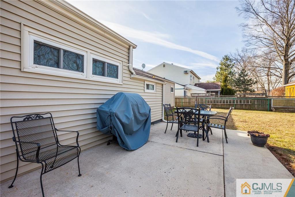 156 Winthrop Road Edison, NJ 08817 - Photo 13 of 28 a view of a patio with table and chairs with wooden fence and plants