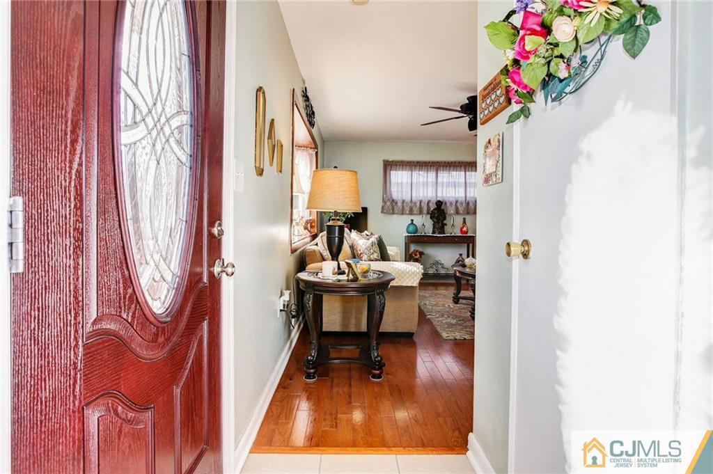 156 Winthrop Road Edison, NJ 08817 - Photo 16 of 28 a living room with furniture and a dining table with wooden floor
