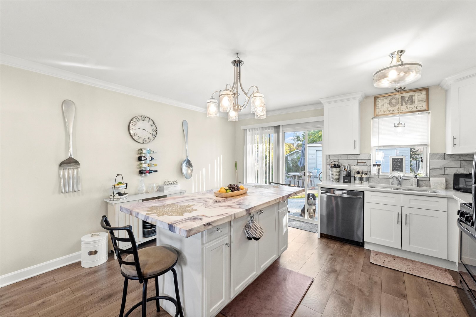 7749 South Octavia Avenue Bridgeview, IL 60455 - Photo 13 of 35 a large white kitchen with a stove a sink dishwasher a dining table and chairs with wooden floor