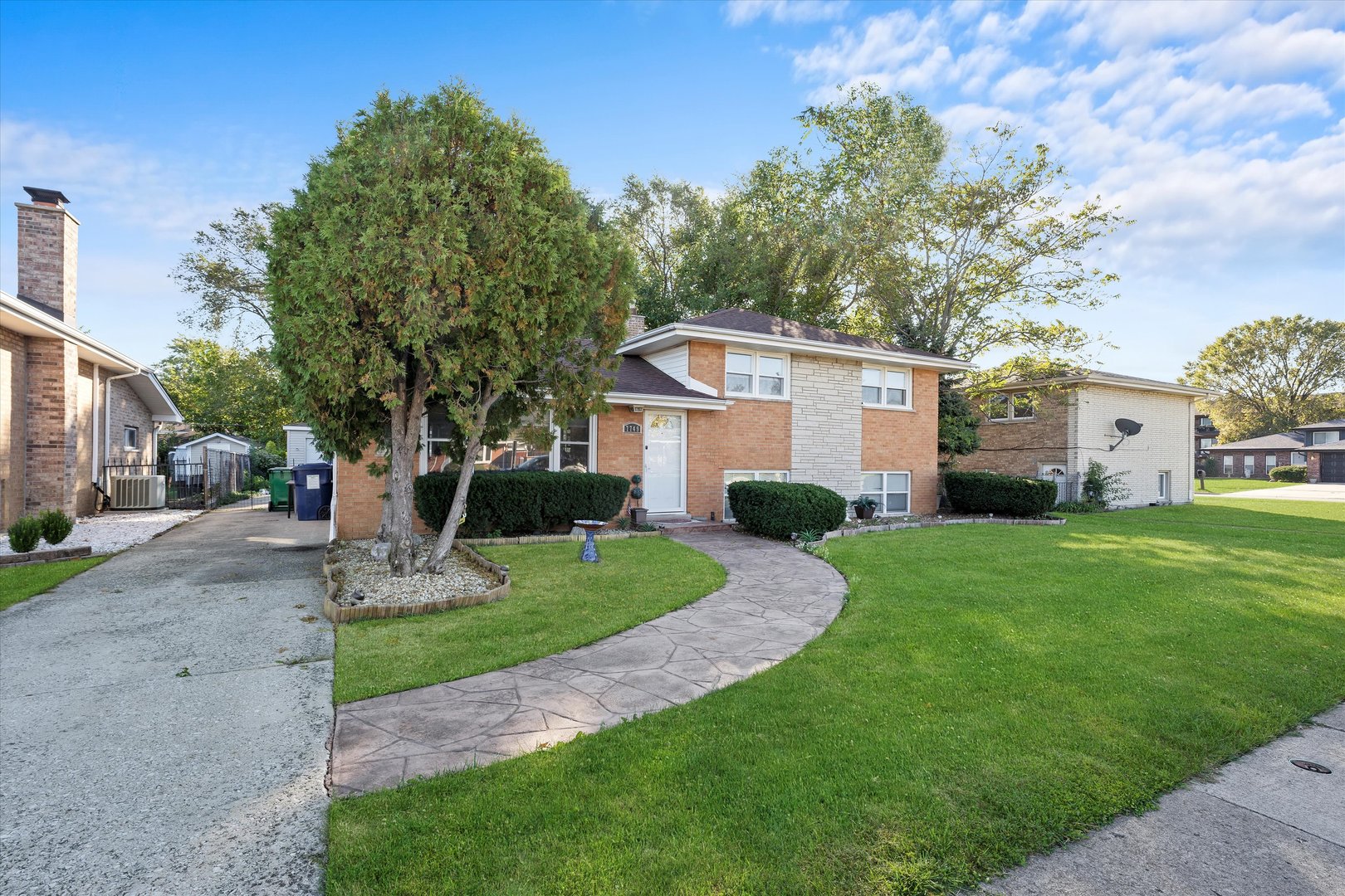 7749 South Octavia Avenue Bridgeview, IL 60455 - Photo 4 of 35 a front view of a house with a yard and trees