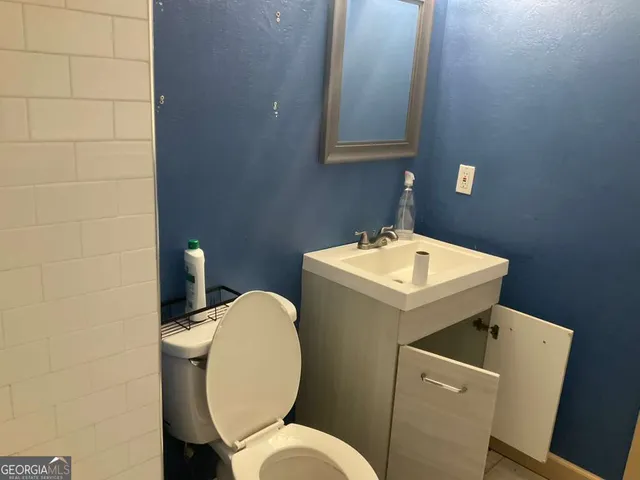 a bathroom with a sink a toilet and a mirror