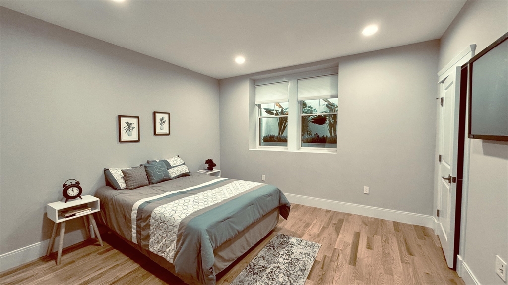 7 Whitman Street, Unit 1 Somerville, MA 02144 - Photo 11 of 35 a bedroom with a bed and wooden floor