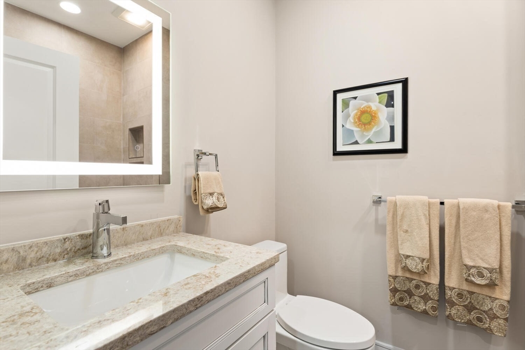 7 Whitman Street, Unit 1 Somerville, MA 02144 - Photo 12 of 35 a bathroom with a granite countertop sink mirror vanity and toilet
