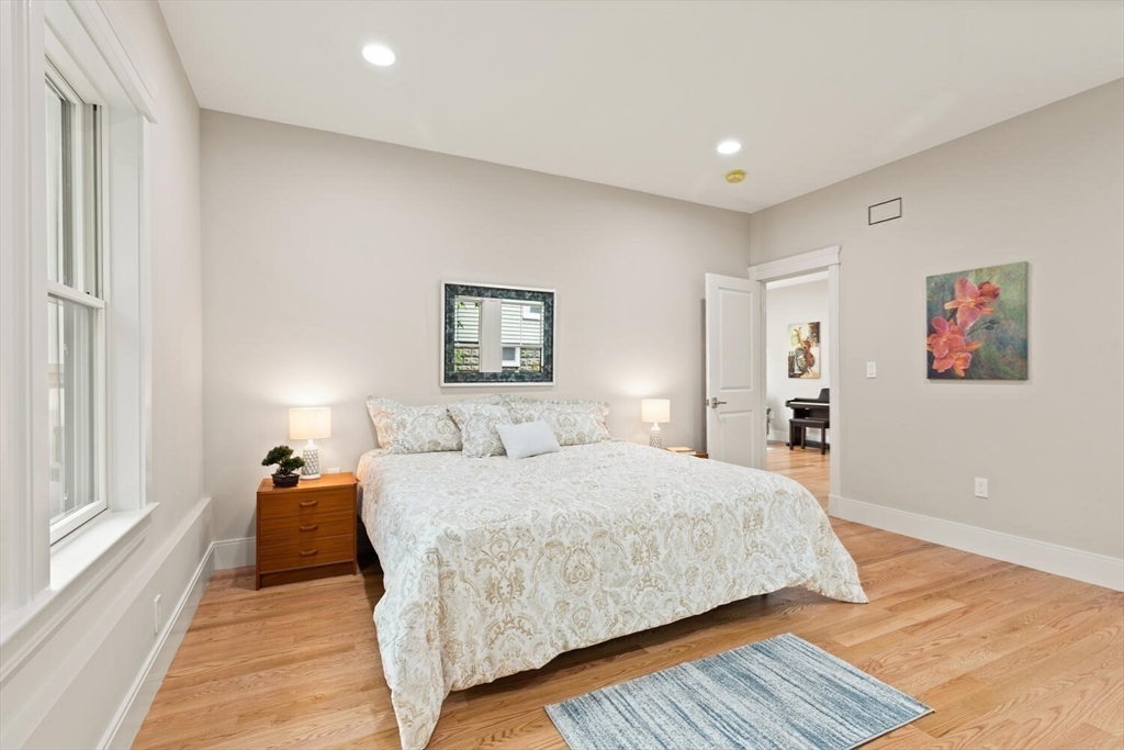 7 Whitman Street, Unit 1 Somerville, MA 02144 - Photo 22 of 35 a bedroom with a bed and a large mirror