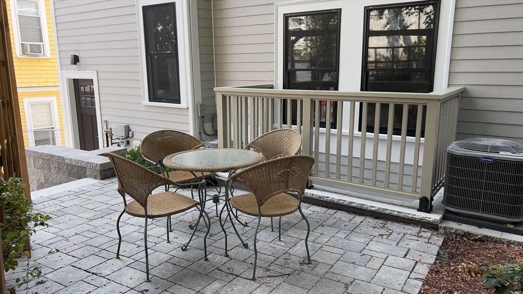 7 Whitman Street, Unit 1 Somerville, MA 02144 - Photo 31 of 35 a view of a chair and table in the back yard of the house