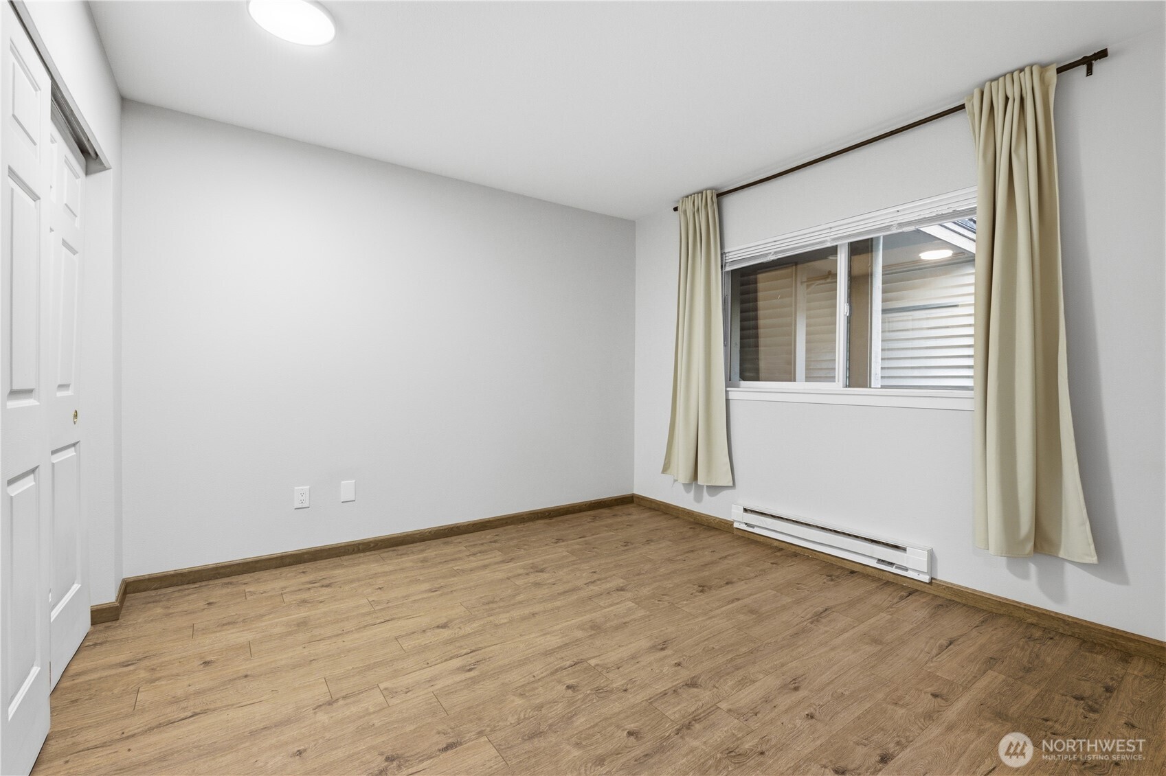 15340 Macadam Road South, Unit B206 Tukwila, WA 98188 - Photo 8 of 29 an empty room with wooden floor and windows