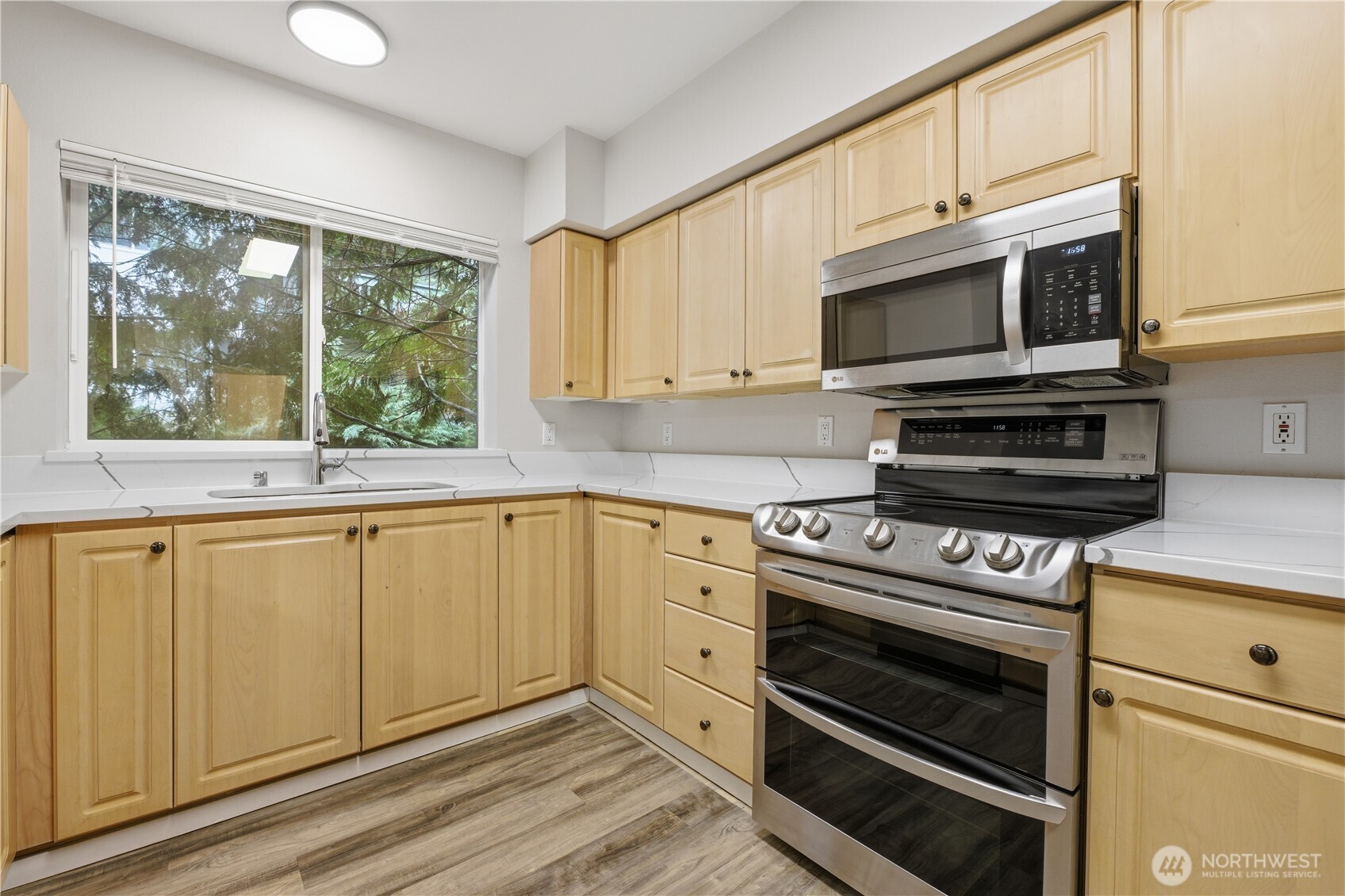 15340 Macadam Road South, Unit B206 Tukwila, WA 98188 - Photo 10 of 29 a kitchen with stainless steel appliances white cabinets and a stove top oven