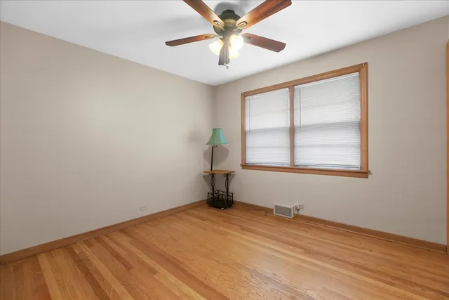 an empty room with a window and a ceiling fan
