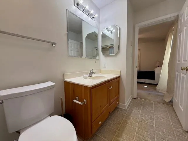 a bathroom with a sink vanity mirror and toilet