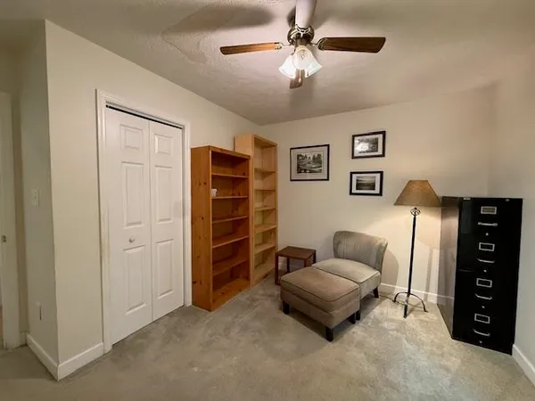 a living room with furniture and a ceiling fan