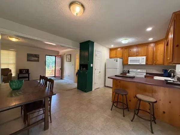 a kitchen with a table chairs refrigerator and cabinets