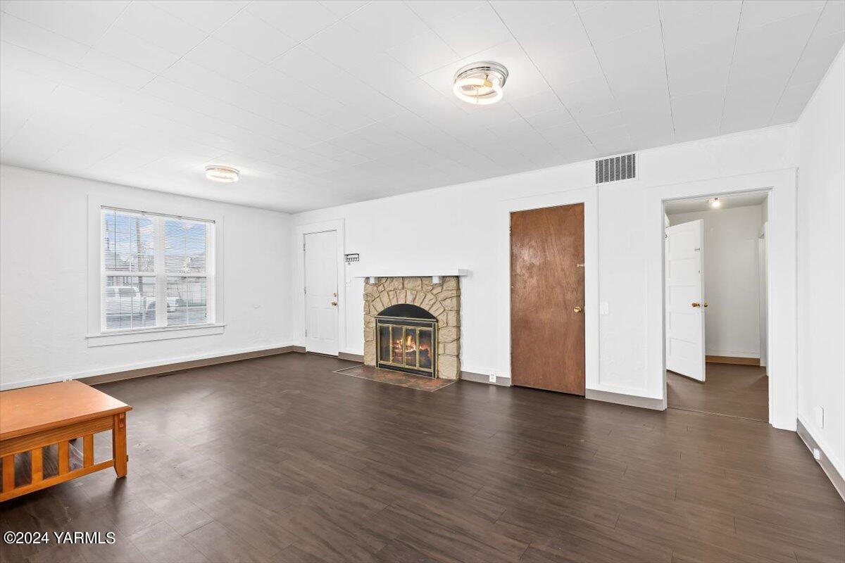 710 East Walnut Street Yakima, WA 98901 - Photo 5 of 15 an empty room with windows fireplace and wooden floor