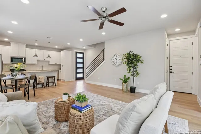 a living room with furniture kitchen view and a potted plant