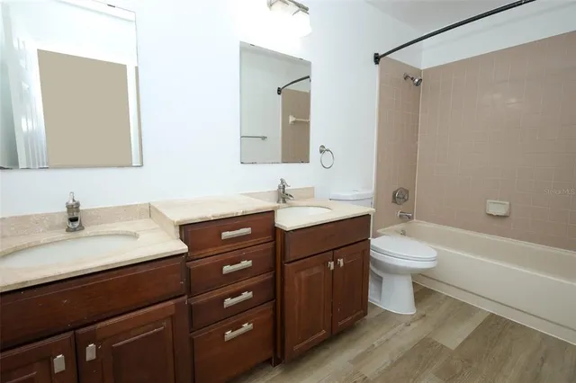 a bathroom with a granite countertop sink a toilet and a bathtub
