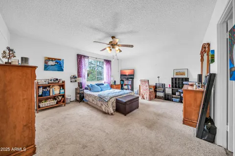a living room with furniture a flat screen tv and a chandelier