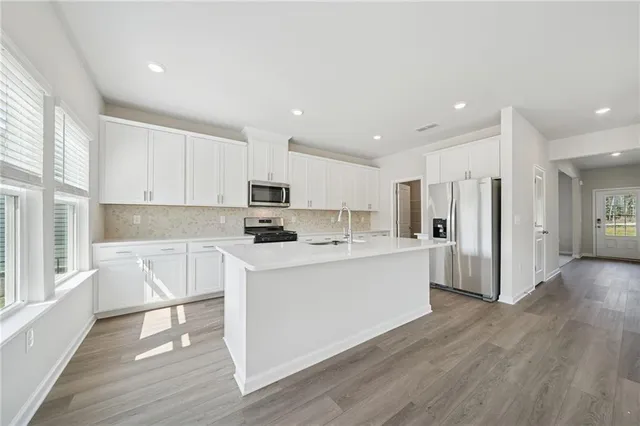 a kitchen with white cabinets and counter space