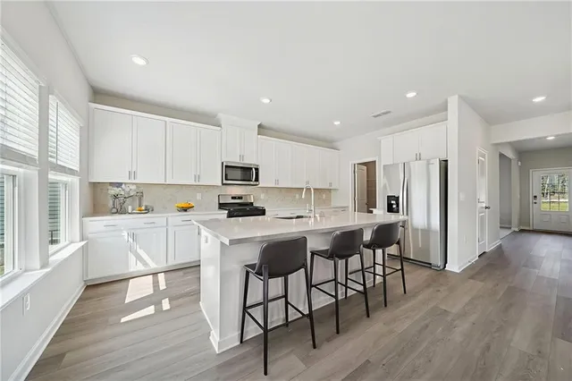 a kitchen with stainless steel appliances granite countertop a stove and a wooden floors