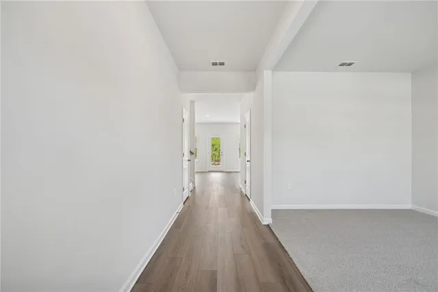 a view of a hallway with wooden floor and staircase
