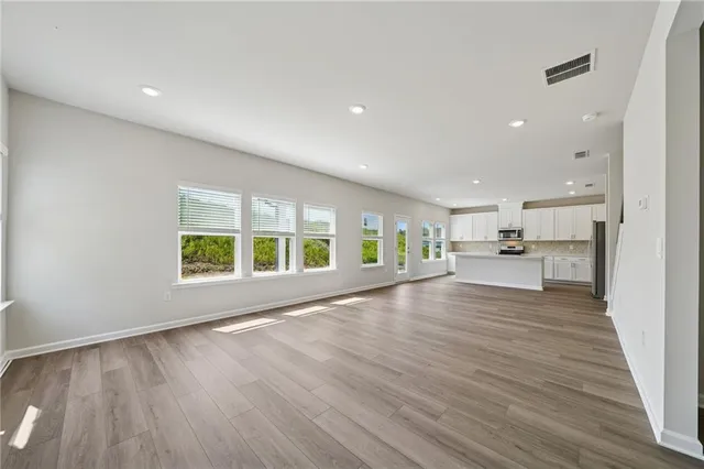 a view of a hallway with wooden floor and windows