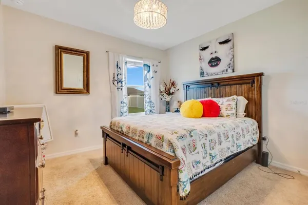 a bedroom with a bed and a chandelier