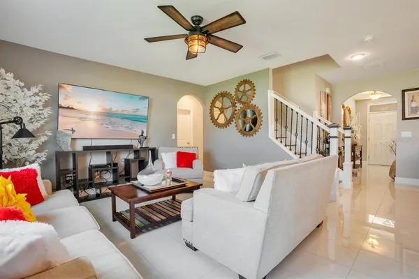 a living room with furniture and a ceiling fan