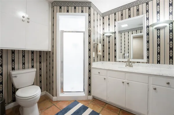 a bathroom with a granite countertop toilet sink and a mirror