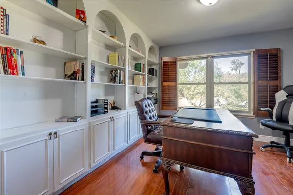 a view of a workspace with furniture and a window