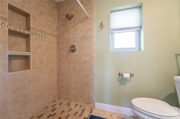 a bathroom with a toilet and a shower