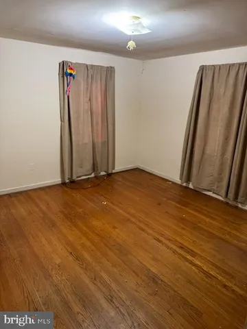 an empty room with wooden floor and a window