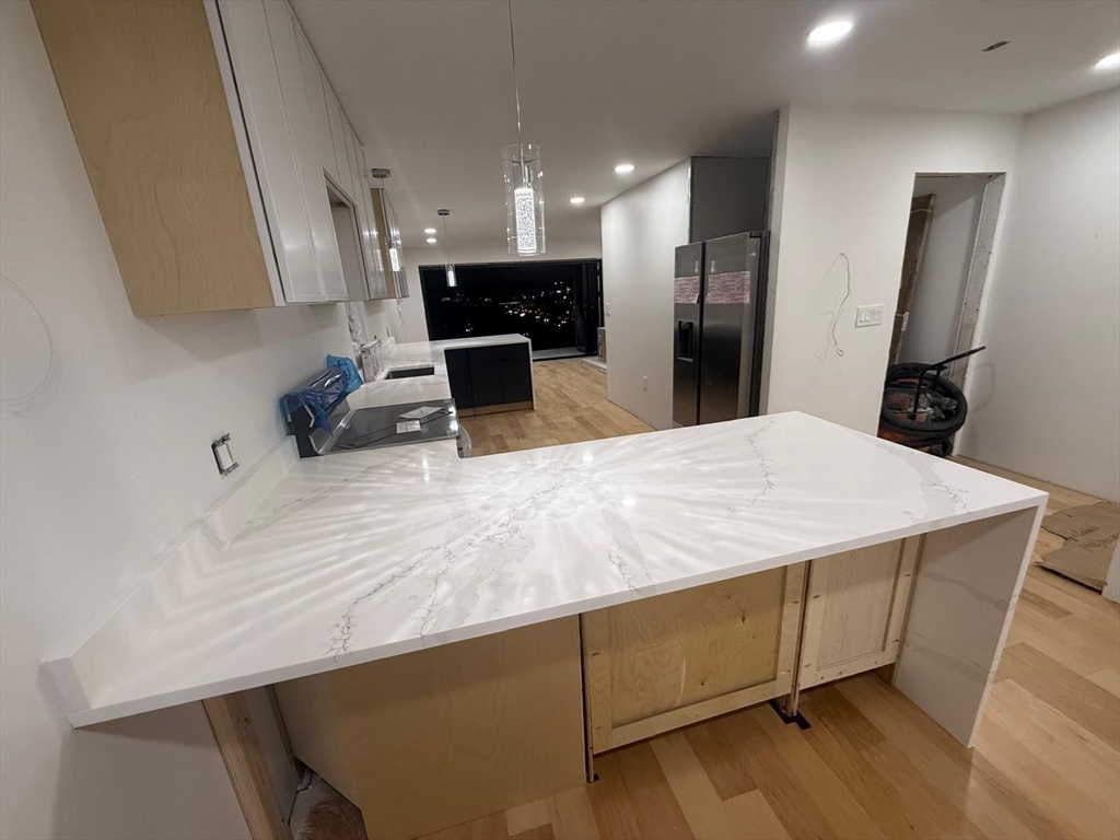 47 Laurel Street, Unit 47 Worcester, MA 01605 - Photo 11 of 23 a room with kitchen island a sink wooden floor and living room view