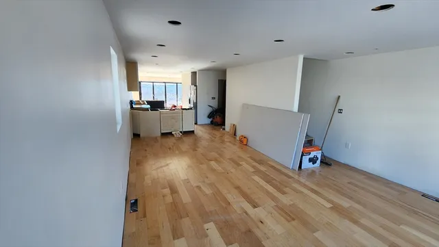 a view of a room with wooden floor and a window