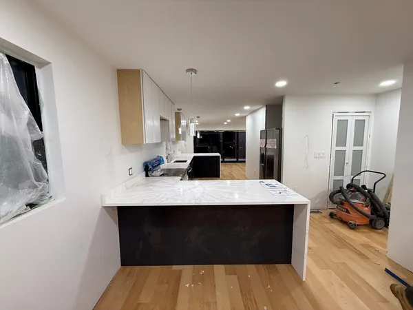 a kitchen with kitchen island granite countertop a sink stove and refrigerator