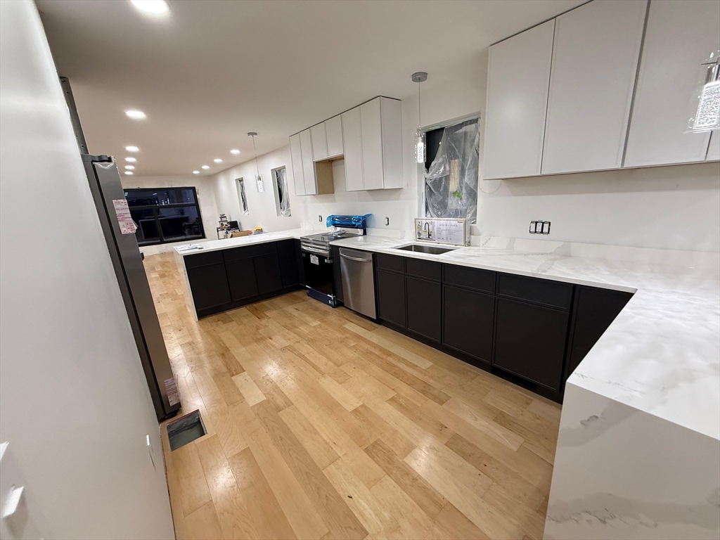 47 Laurel Street, Unit 47 Worcester, MA 01605 - Photo 22 of 23 a kitchen with kitchen island granite countertop a sink stove and refrigerator