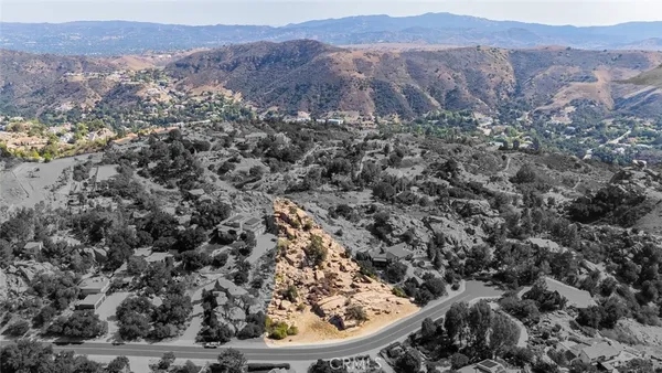 an aerial view of house with yard and mountain view in back