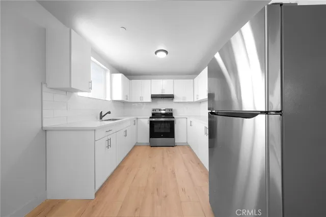 a view of a kitchen with sink and cabinets