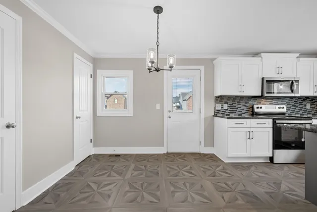 a kitchen with granite countertop a stove a sink and a refrigerator