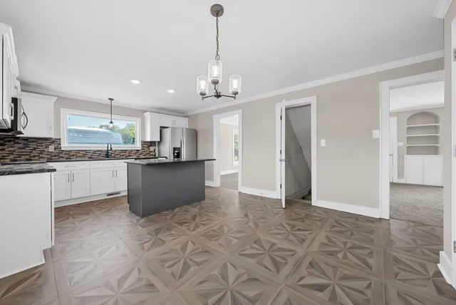 a kitchen with stainless steel appliances granite countertop a refrigerator and a sink