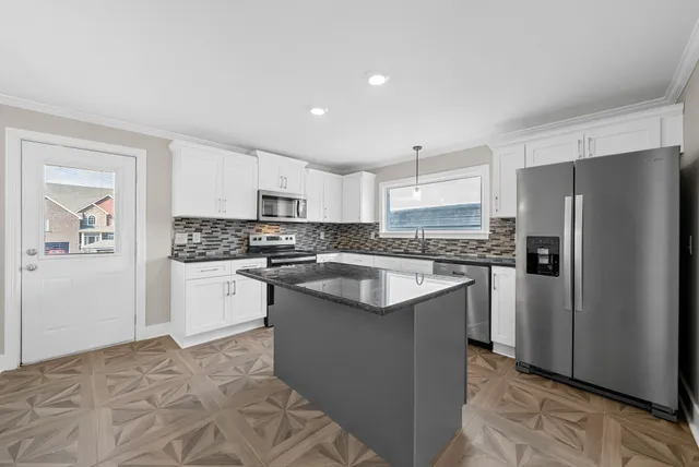 a kitchen with granite countertop a sink a window and cabinets