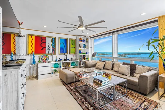 a living room with furniture ceiling fan and a large window
