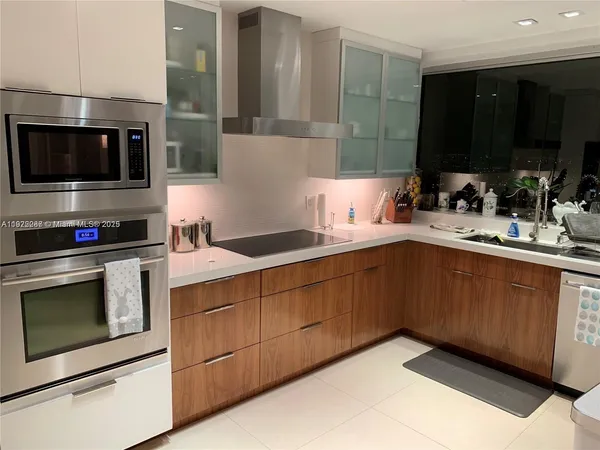 a kitchen with stainless steel appliances granite countertop a sink and a stove top oven with wooden floor