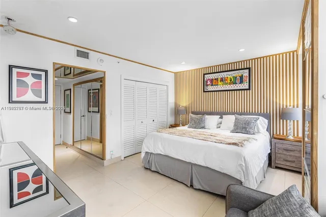 a spacious bedroom with a bed and a refrigerator