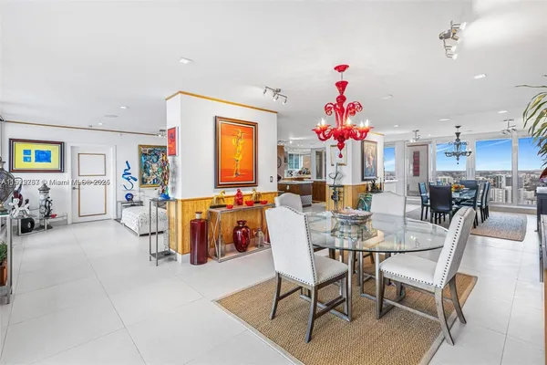a living room with furniture a chandelier and a dining table