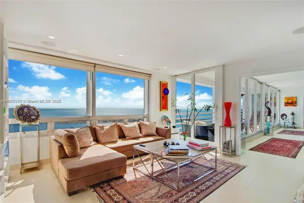 a living room with patio furniture and a floor to ceiling window