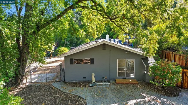 a view of a house with a tree in front of it