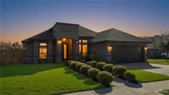 a backyard of a house with table and chairs potted plants and a large tree