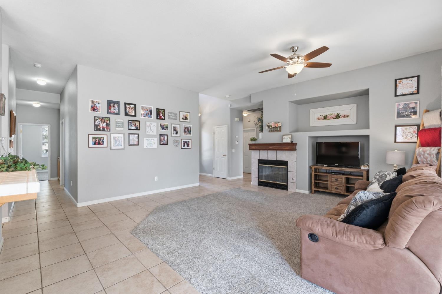 1757 Homestead Way Lemoore, CA 93245 - Photo 6 of 35 a living room with furniture a fireplace and a window
