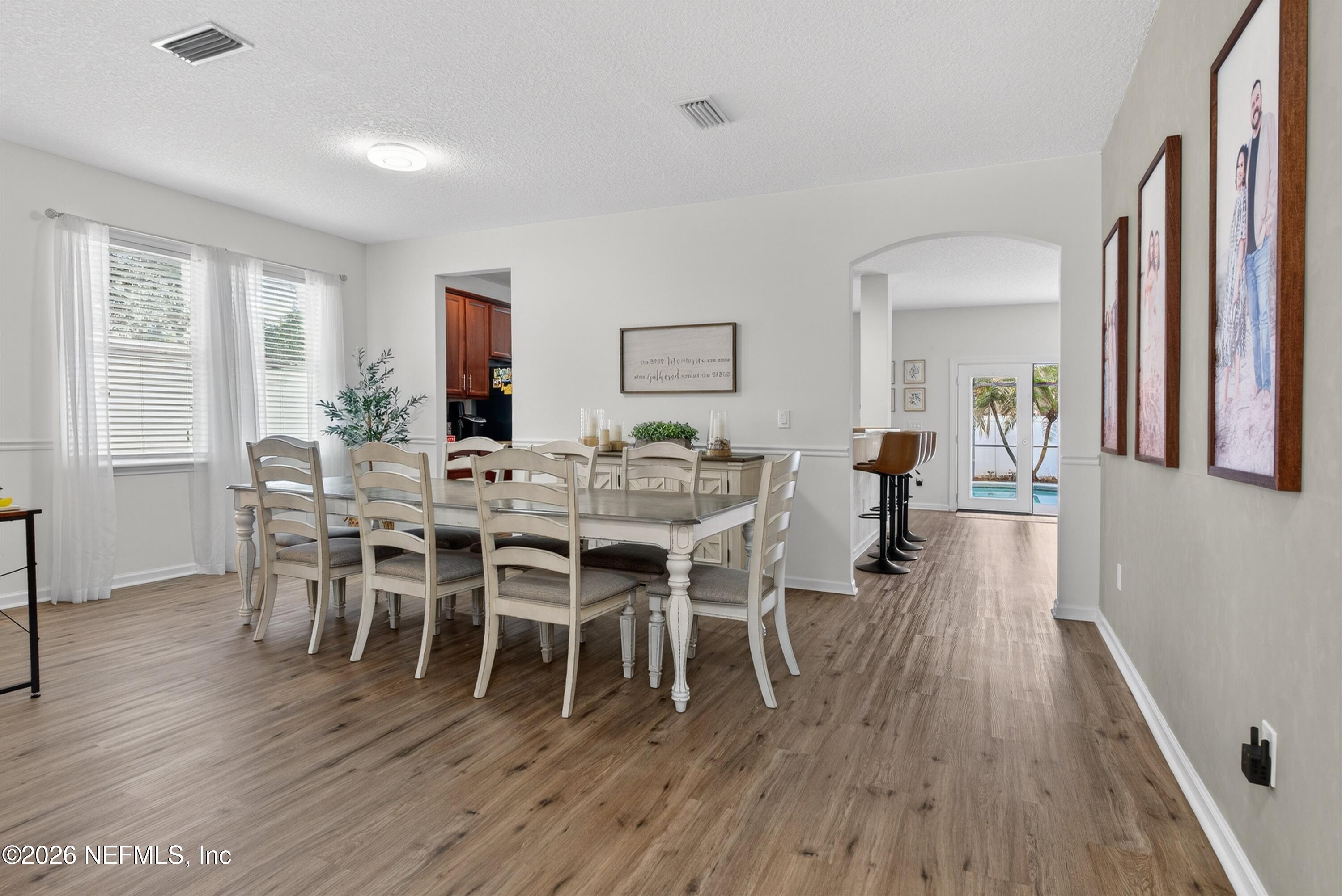 1214 South Kyle Way St. Johns, FL 32259 - Photo 11 of 78 a dining room with wooden floor a chandelier a glass table and chairs