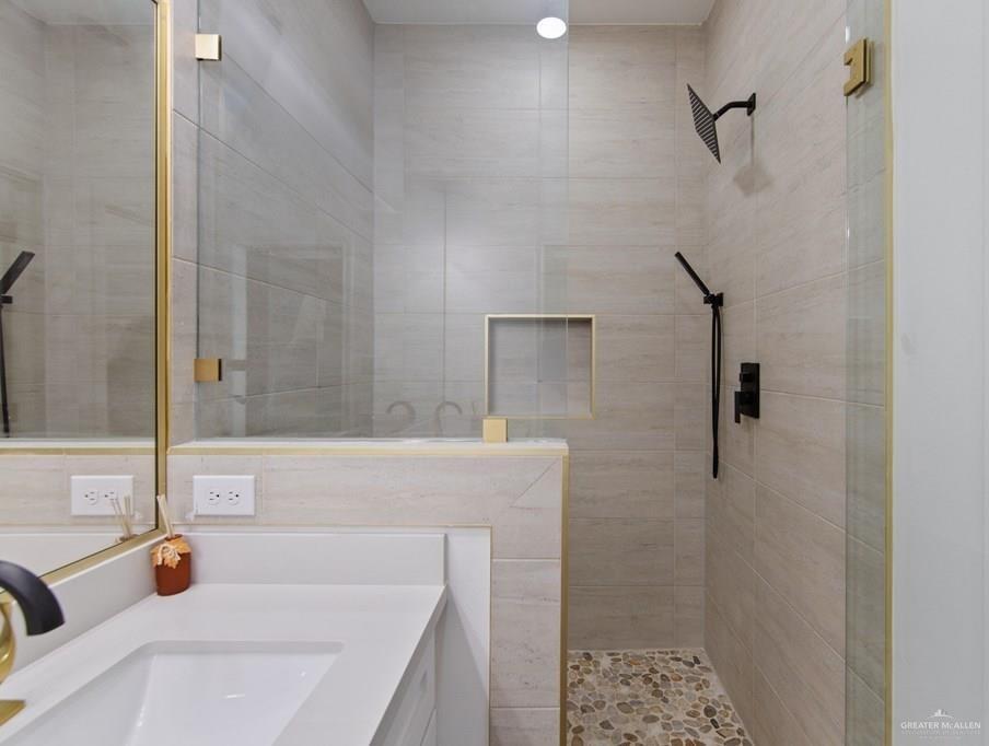 18002 Spruce Street Harlingen, TX 78552 - Photo 16 of 29 a bathroom with a tub a sink and a granite counter top